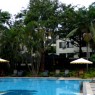 El área de la piscina del hotel Jacaranda con su jardín y las mesas del restaurante y cafetería forman un espacio delicioso